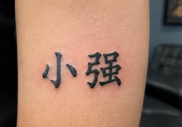 A tattoo reading Xiǎo Qiáng